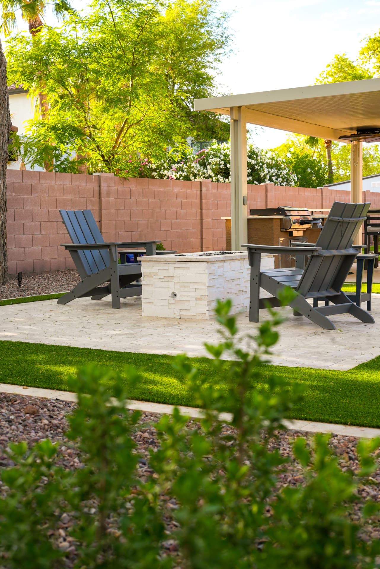 Fire pit seating area with covered outdoor kitchen behind