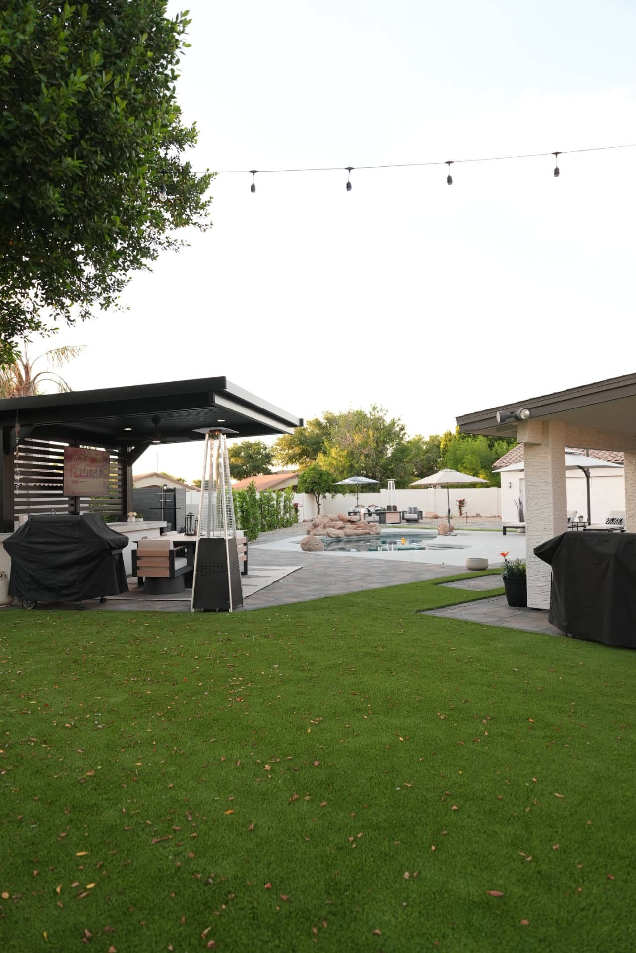 Backyard turf lawn with pavilion on the left and pool beyond