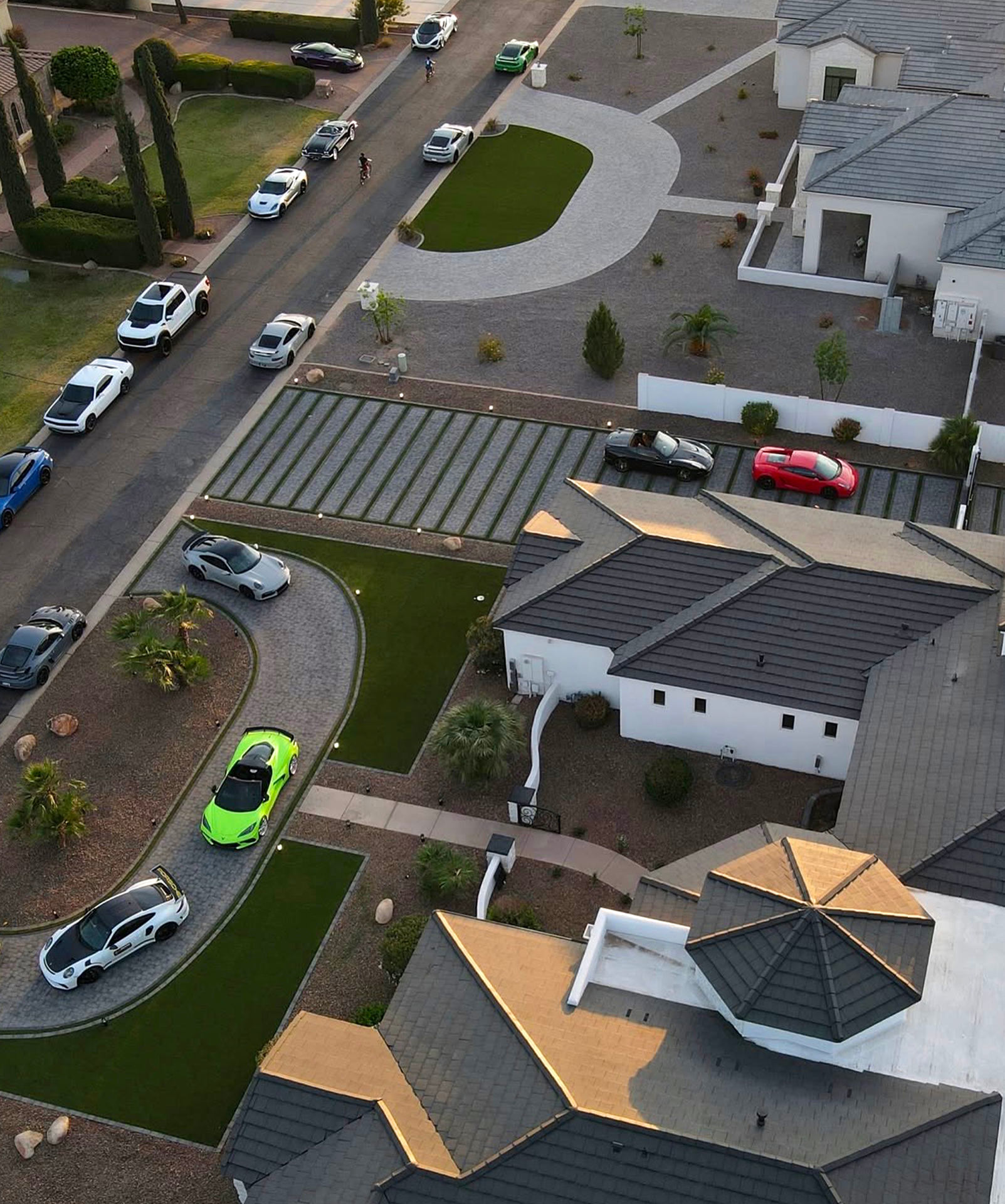 Overhead view of paver bands with turf ribbon inlays and parked sports cars