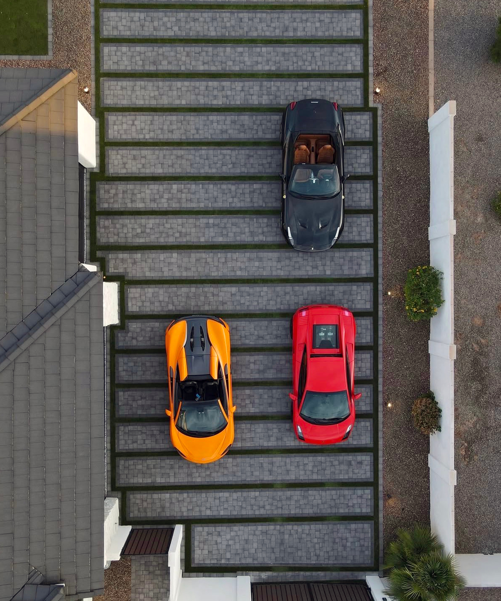 Aerial view of a wide banded paver parking apron beside the home