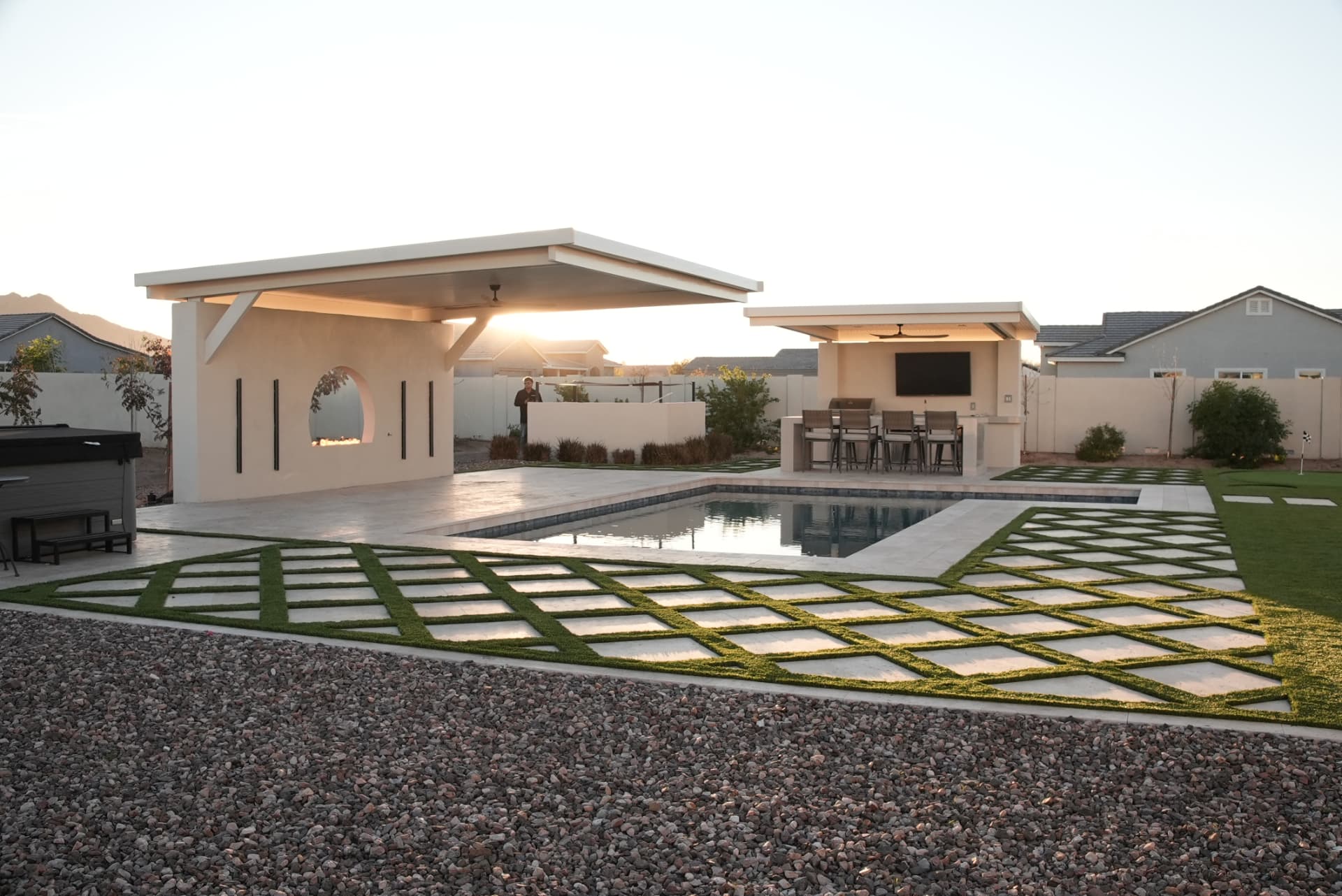 Diamond pattern travertine pavers with turf joints beside a pool