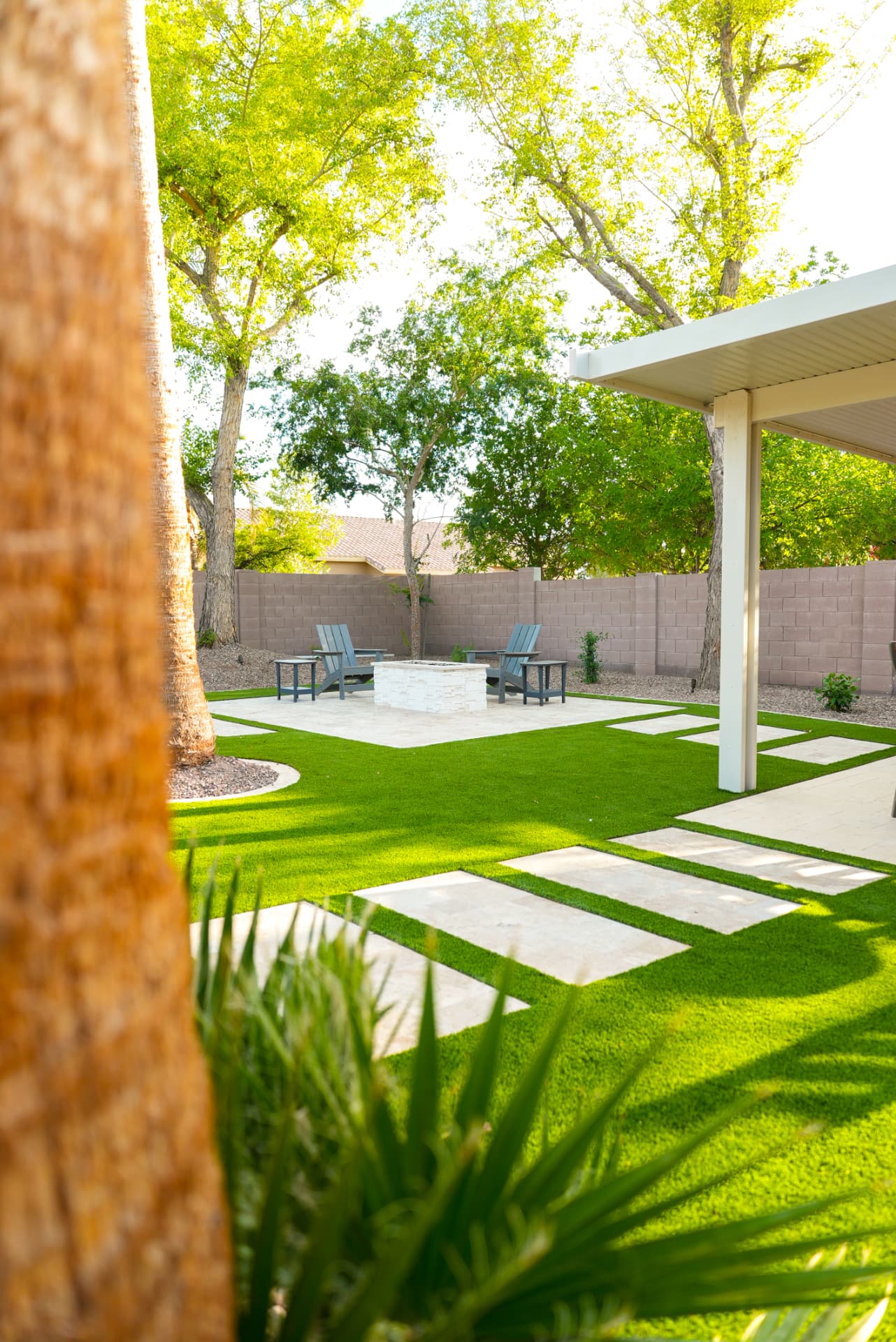 Backyard with turf lawn, stepping stones and patio cover
