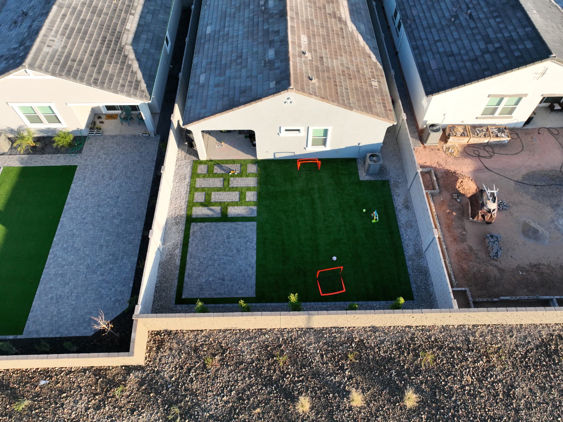 Overhead drone view of a finished backyard with turf and pavers
