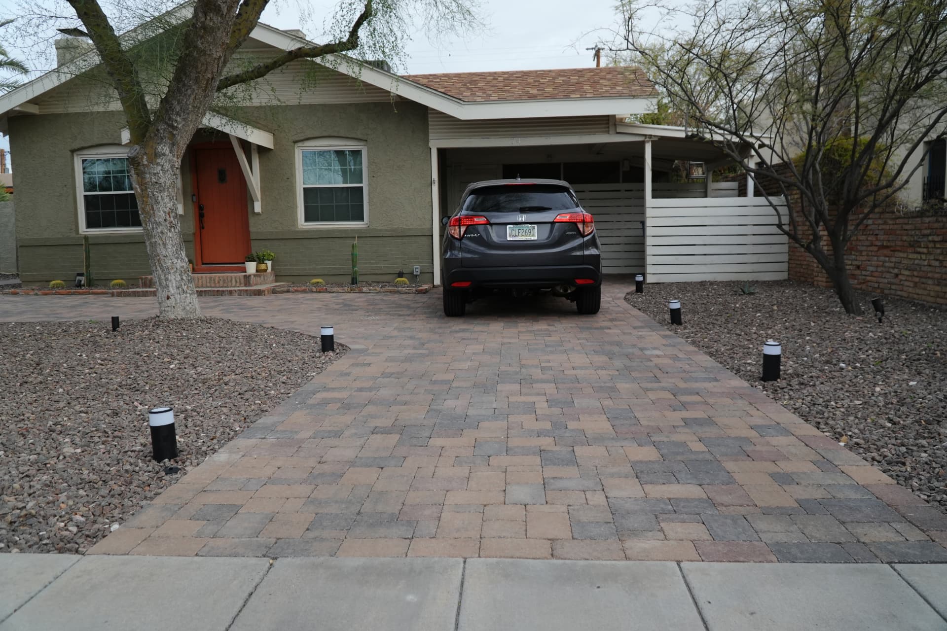 New multi-tone paver driveway leading to a carport at a historic Phoenix bungalow