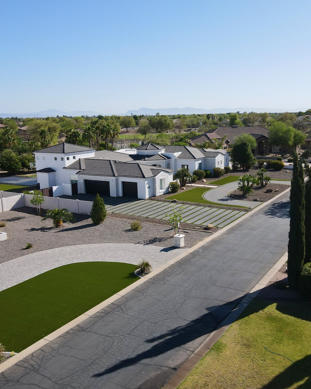 Street-level aerial approach to the estate driveway and turf panels
