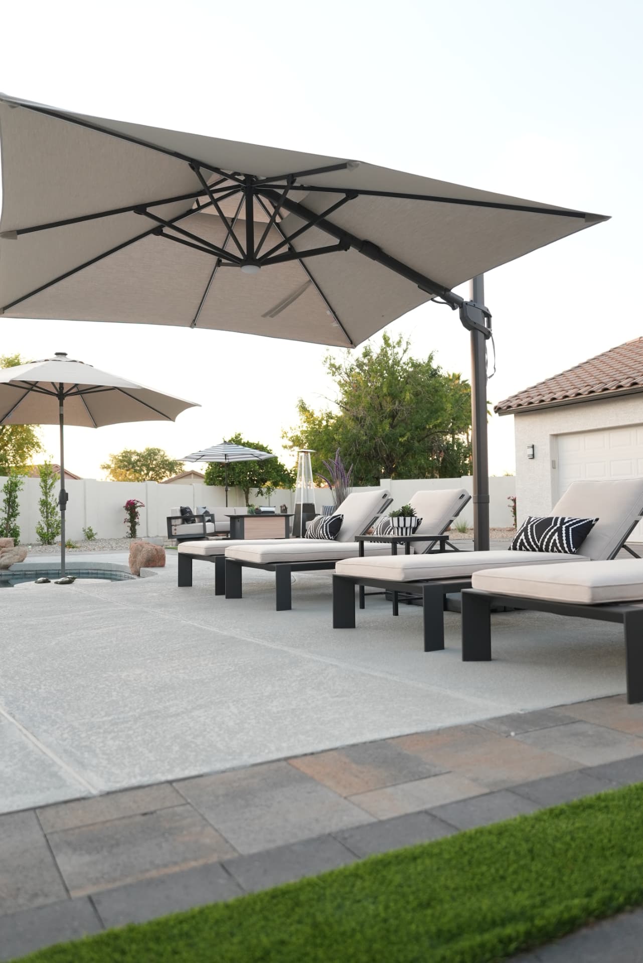 Row of loungers under umbrellas on a pool deck at golden hour